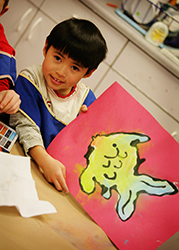 proof7844web Rivendell student displaying colorful fish painting | Best Elementary School Fort Collins